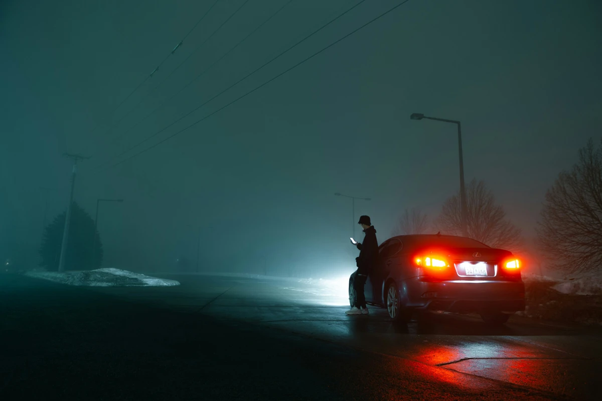 Junger Mann mit Mobiltelefon lehnt an Lexus Fahrzeug bei Nacht und Nebel, Tpd Medien GmbH in München-Pasing, Grafiker, Designer, Webdesigner, Agentur, Werbung
